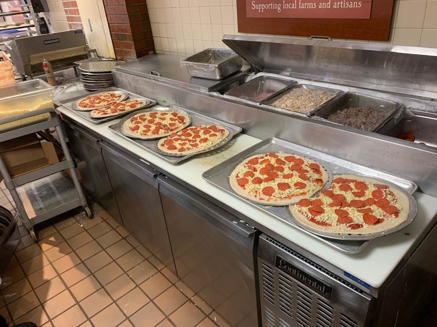 Fresh Pizzas Prepped for Baking in a Commercial Kitchen