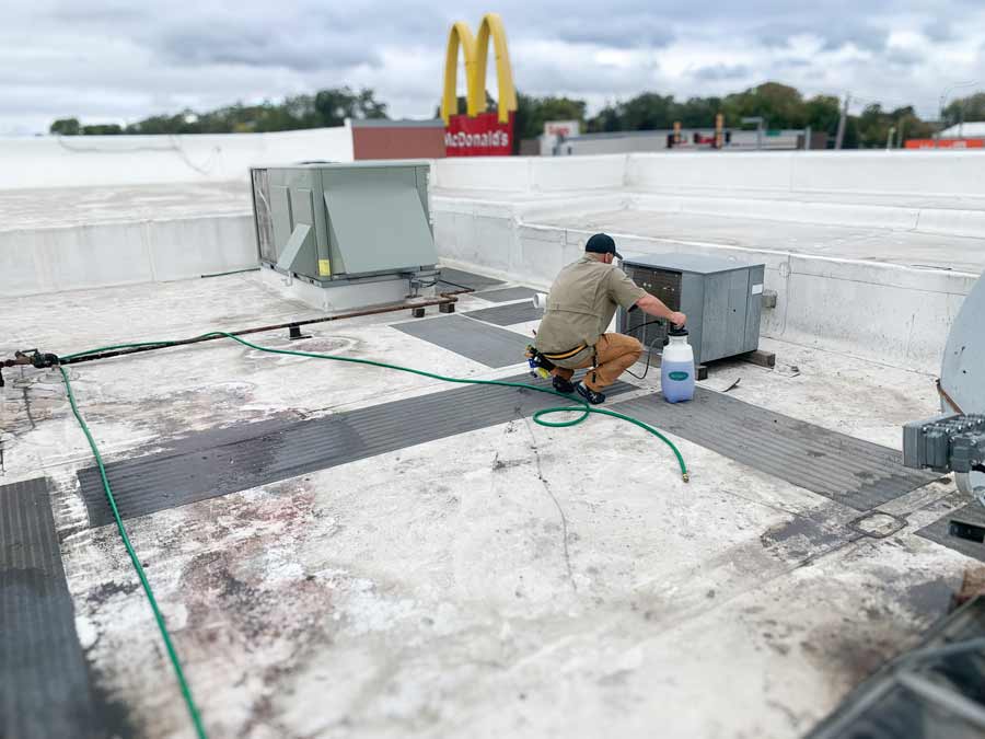 TopShot Tech works on rooftop equipment for a professional kitchen during a service call.